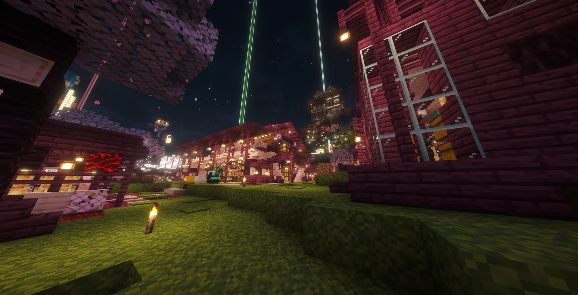 A lantern-lit cherry market street and hillside builds at night