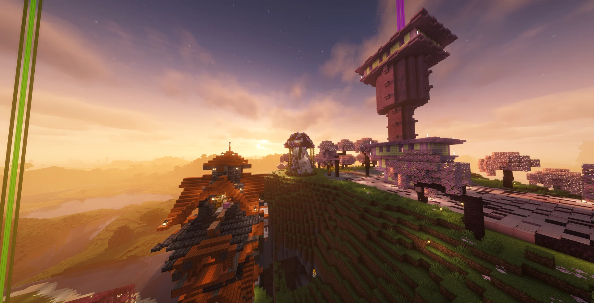 A tall pink tower and hillside builds glowing at sunrise